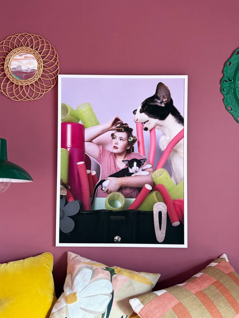Collage Vivant av Lisbet Spörndly, fotokonst i miljö med verk hängande ovanför soffa mot rosa vägg